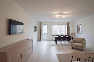 - un salon avec une télévision et une table avec des chaises dans l'établissement Norden Homes Turku Central 2-Bedroom Apartment, à Turku