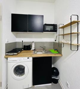 eine Küche mit einer Spüle und einer Waschmaschine in der Unterkunft Traumhaftes 1-Zi Apartment mit Gartennutzung Nähe Krefeld HBF in Krefeld