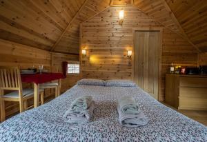フォート・ウィリアムにあるLeven View Lodges - Callartの木造キャビン内のベッド1台が備わるベッドルーム1室を利用します。 +3枚の写真