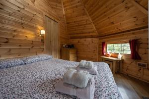a bedroom with a bed in a wooden cabin at Leven View Lodges - Callart in Fort William