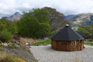 a small house with a black roof in a garden at Leven View Lodges - Callart in Fort William