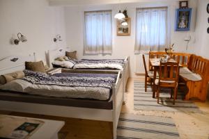 Veľká ChocholnáにあるUbytovanie na dedineのテーブルとダイニングルームが備わる客室で、ベッド2台が備わります。