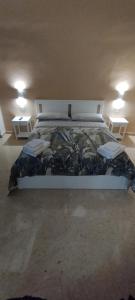 een groot bed in een kamer met 2 tafels bij L'Incanto del Borgo Antico- Locazione Turistica in Bari