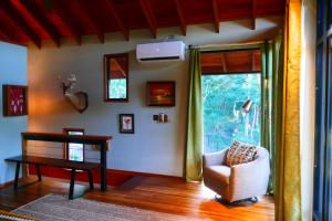 uma sala de estar com uma cadeira, uma mesa e uma janela em RiverHill Hideaway em Monkey Fall