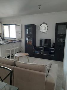 a living room with a couch and a tv and a kitchen at Apartamento vacacional en Orzola Lanzarote in Orzola