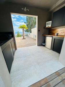 una cocina con una gran puerta abierta a un patio en CASA LC chambre1 vue Mer Jacuzzi en Ajaccio