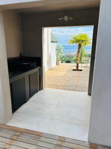 - une vue sur une cuisine avec un palmier dans l'établissement CASA LC chambre1 vue Mer Jacuzzi, à Ajaccio