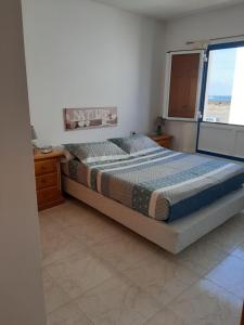Un dormitorio con una cama grande y una ventana en Apartamento vacacional en Orzola Lanzarote, en Orzola