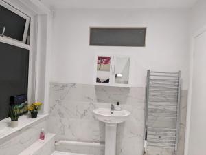 a white bathroom with a sink and a shower at Charming 4-Bedroom House in Dover in Dover