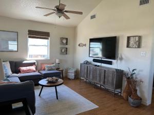 un soggiorno con divano e TV a schermo piatto di Sunshine DayDream by SurfBreakLLC a Surfside Beach