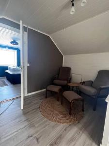 sala de estar con 2 sillas y mesa en Storgata 5, en Berlevåg