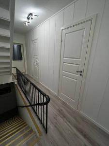 a hallway with a white door and a staircase at Storgata 5 in Berlevåg
