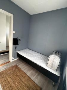 1 dormitorio con 1 cama en una pared azul en Storgata 5, en Berlevåg