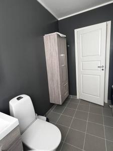 a bathroom with a white toilet and a white door at Storgata 5 in Berlevåg