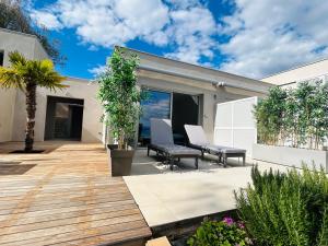 a patio with two chairs and a palm tree at CASA LC chambre2 vue Mer Jacuzzi in Ajaccio