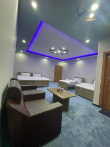 a room with two beds and a purple ceiling at River Garden Hotel and Resort in Naran