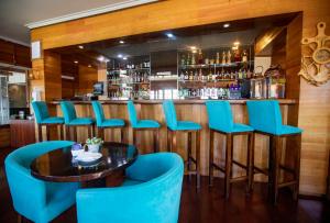 a bar with blue chairs and a table at Gran Hotel Vicente Costanera in Puerto Montt