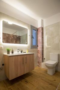 a bathroom with a toilet and a sink and a mirror at Vonitsa Luxury Apartments in Vonitsa