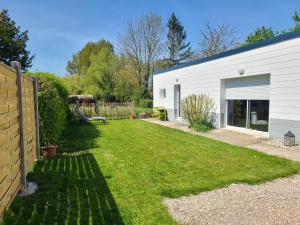 einen Hof mit einem weißen Gebäude und einem Zaun in der Unterkunft Gîte Les amoureux de la Baie in Favières