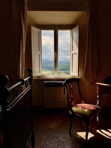 Cette chambre dispose d'une fenêtre avec une chaise et une fenêtre. dans l'établissement Casa Cerboneschi, à Casale Marittimo