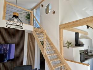 uma escada de madeira numa sala de estar com uma cozinha em Lieblingsort am Moor em Gnarrenburg