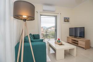 a living room with a blue couch and a flat screen tv at Vonitsa Luxury Apartments in Vonitsa
