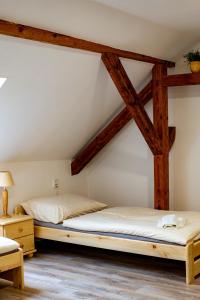 twee bedden in een kamer met houten balken bij Apartmán Pod Zámkem in Moravský Krumlov