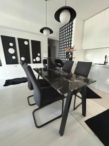 een eetkamer met een zwarte tafel en stoelen bij Sandev apartments Black&White in Štip