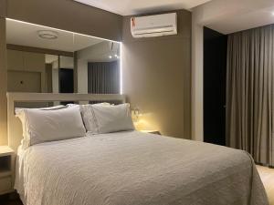 Un dormitorio con una cama blanca con un espejo. en Beira Mar com Excelente Localização, en Balneário Camboriú 122 fotos más