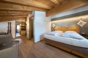 a bedroom with a large bed with a wooden headboard at Aparthotel Grischuna in Samnaun