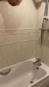 a white bath tub with a faucet in a bathroom at Harper Close in West Thurrock