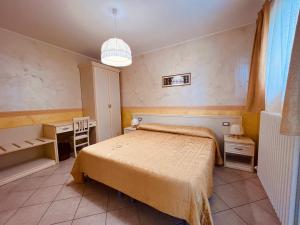 a bedroom with a bed and a desk and a lamp at b&b DOREMI in Osimo