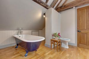 a large bathroom with a large tub and a toilet at Williams Barn in West Beckham +21 photos