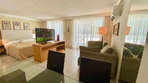 a living room with a bed and a television at Varandas 108 Ponta Negra Praia - NBI - (Perto da Praia e Morro de Careca) in Natal +53 photos