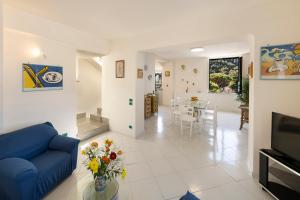 - un salon avec un canapé bleu et une table dans l'établissement Relais del mare con terrazza fronte mare free parking, à Massa Lubrense