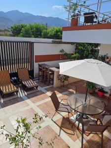 a patio with a table and chairs and an umbrella at Villa Layla Santa Marta in Santa Marta