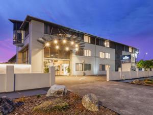 un gran edificio blanco con luces encendidas en JetPark Hotel Rotorua, en Rotorua