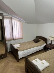 - une chambre avec 2 lits et une fenêtre dans l'établissement Apartmani Dunja Zlatar, à Nova Varoš