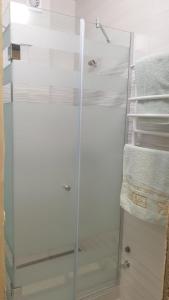 uma cabina de duche em vidro na casa de banho com toalhas em Аренда уютной квартиры на сутки с видом на Море и Есть бомбоубежище em Kryzhanivka