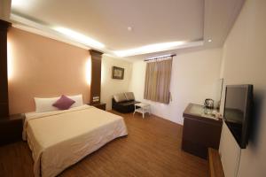 um quarto de hotel com uma cama e uma televisão de ecrã plano em Goden Beach B&B em Eluan