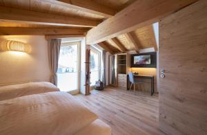 ein Schlafzimmer mit einem Bett und einem Schreibtisch in einem Zimmer in der Unterkunft Aparthotel Grischuna in Samnaun