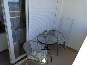 mały stół i krzesła na balkonie w obiekcie Beetlejuice Apartments w Szybeniku