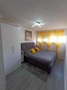 sypialnia z łóżkiem i 2 żółtymi poduszkami w obiekcie Beetlejuice Apartments w Szybeniku