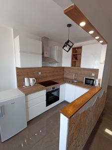 una cucina con armadi bianchi e piano di lavoro di Beetlejuice Apartments a Šibenik
