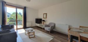Televízia a/alebo spoločenská miestnosť v ubytovaní Duplex proche de Genève et du lac léman