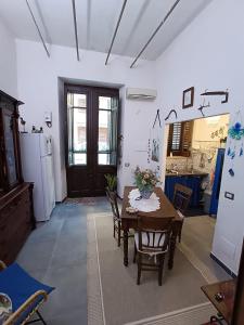 a room with a table and a kitchen with a refrigerator at Syd's House in Bagheria