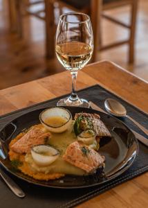 een bord eten en een glas wijn op een tafel bij Pampa Lodge, Quincho & Caballos in Torres del Paine