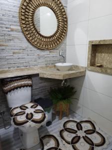 uma casa de banho com um WC, um lavatório e um espelho. em CASA TEMPORADA BARREIRINHAS 2 Quartos em Barreirinhas