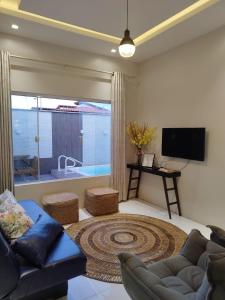 uma sala de estar com um sofá e uma televisão em CASA TEMPORADA BARREIRINHAS 2 Quartos em Barreirinhas