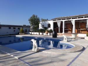 - une piscine en face d'une maison dans l'établissement CASA RURAL SITIO DE CASA NUEVA, à La Guijarrosa